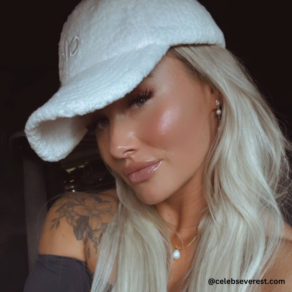 Dani Speegle, sports a white baseball hat, showcasing her casual style and vibrant personality.